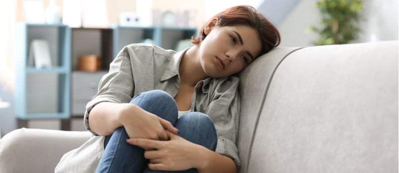 Tanara deprimata stand pe canapea